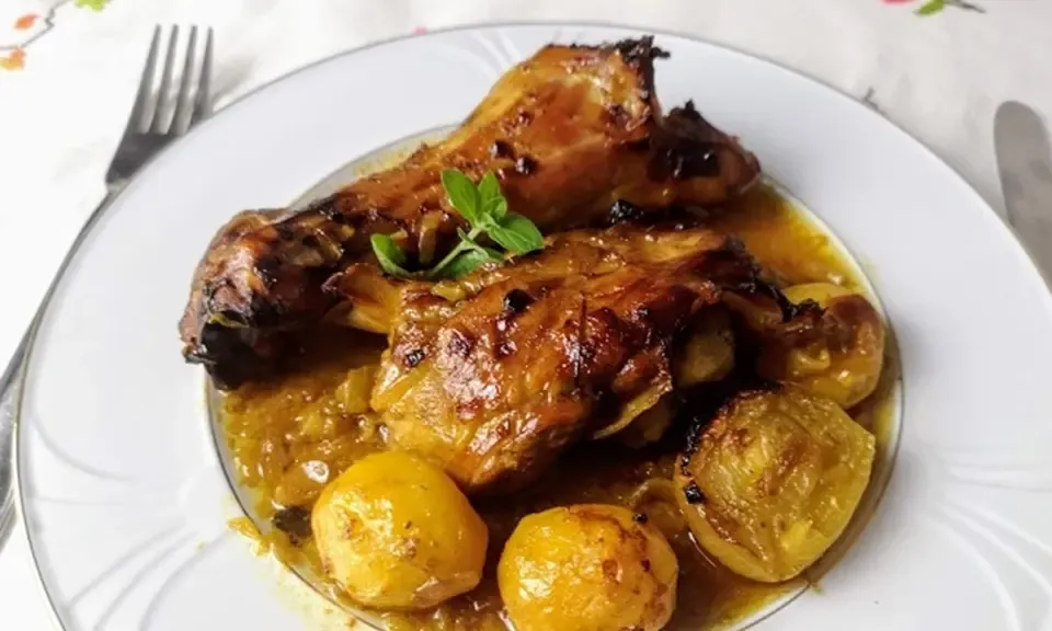Agneau rôti au miel dans sa sauce dorée, servi avec pommes de terre et herbes fraîches