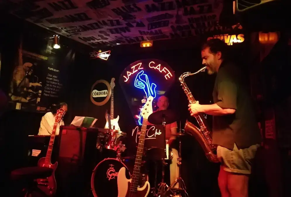 Intérieur intimiste du Jazz Café avec éclairage rouge et affiches de jazz vintage