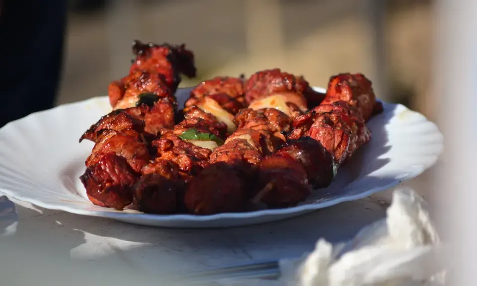 Brochettes de pinchos morunos grillées sur une ardoise avec du pain et une cerveza