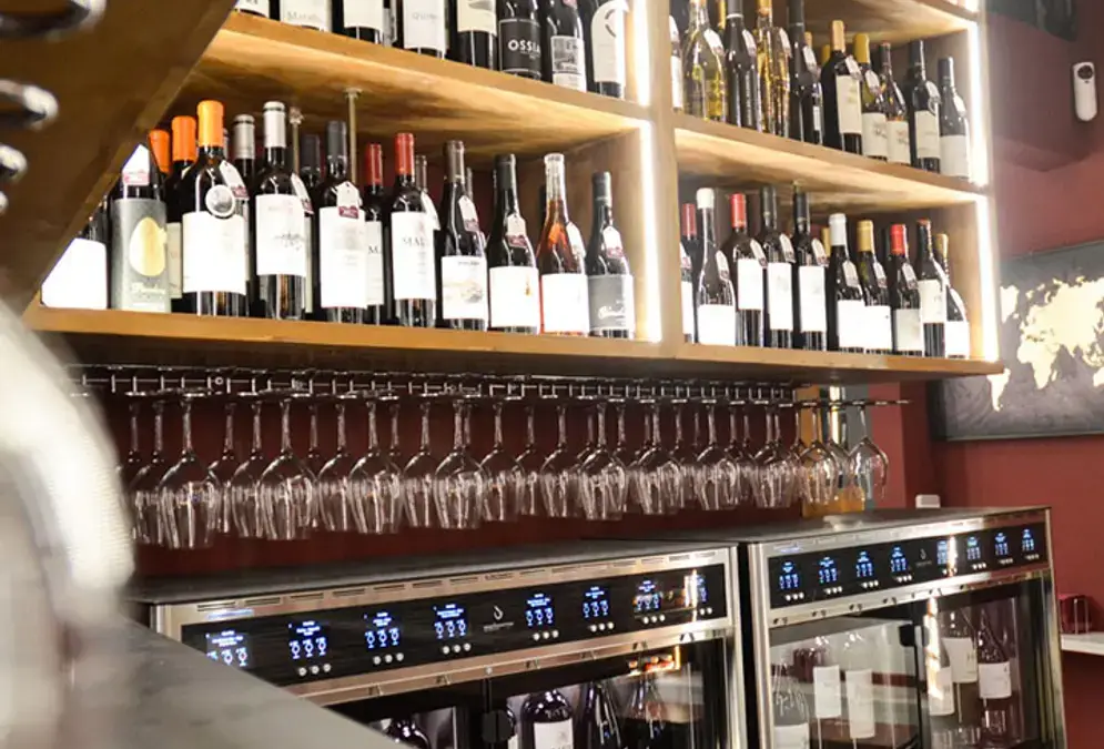 Intérieur du bar à vins VinumPlay avec rangées de bouteilles et décoration contemporaine
