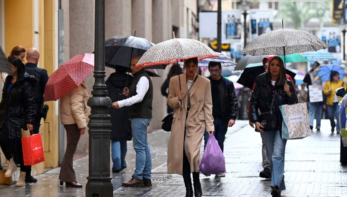 Varias personas se protegen de la lluvia en Córdoba / Juan Ayala