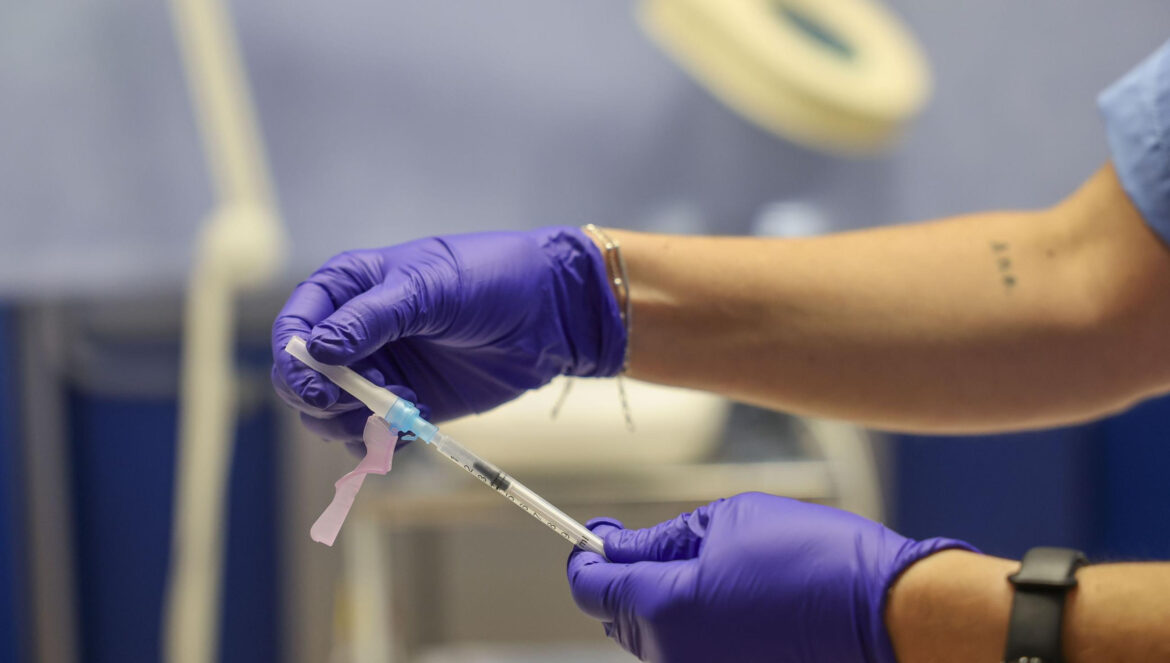 Un profesional sanitario prepara una vacuna contra la gripe / El Día