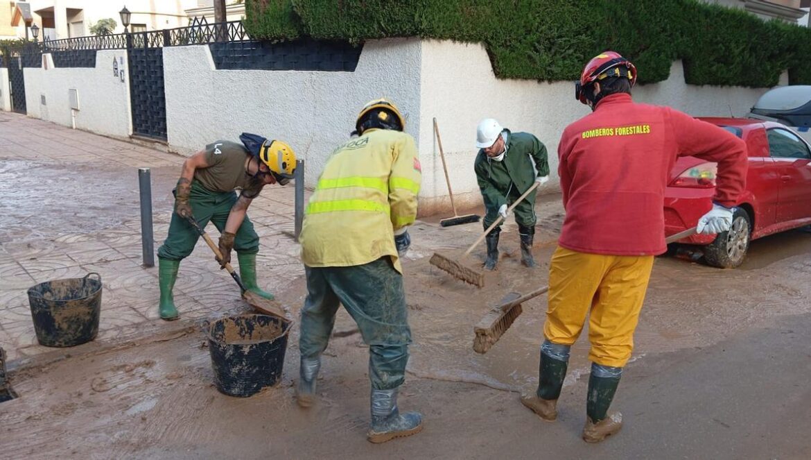 Bomberos forestales voluntarios de Córdoba limpian el barro en Catarroja (Valencia).