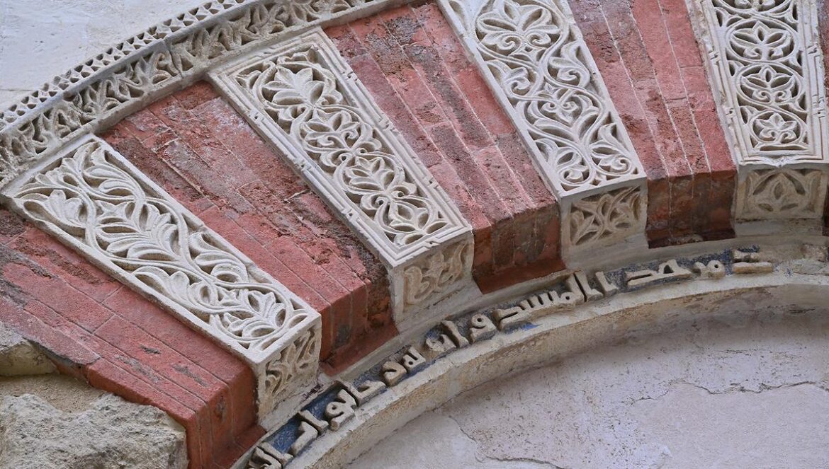Inscripciones originales en la puerta restaurada. La puerta, ya restaurada. Trabajos de restauración en la zona.