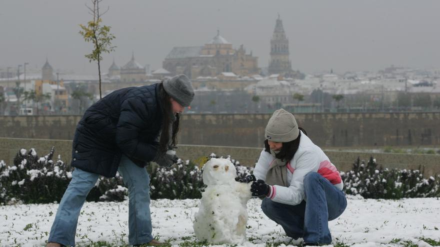 Dos personas hacen un muñeco de nieve en Córdoba en la gran nevada de 2010. / CÓRDOBA