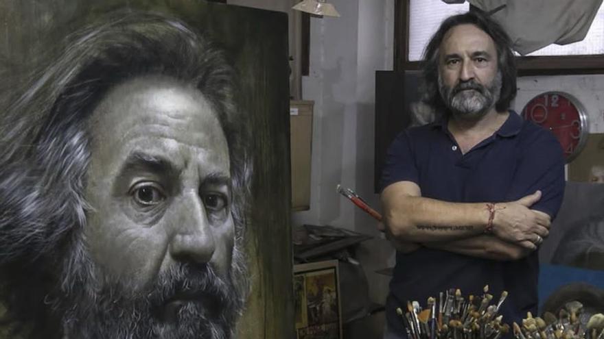 El pintor cordobés Rafael Cervantes posa junto a un autoretrato.. / CÓRDOBA