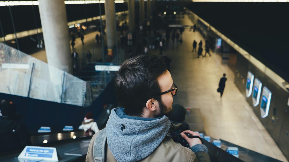 person standing on escalator in subway station