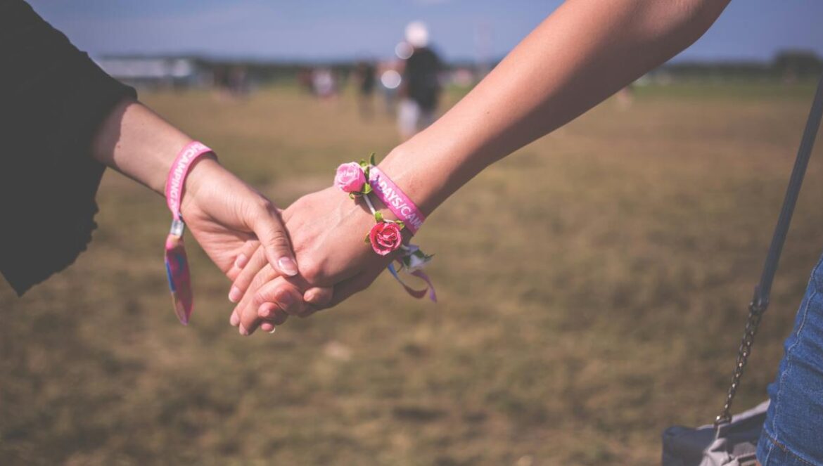 two person holding each other hands