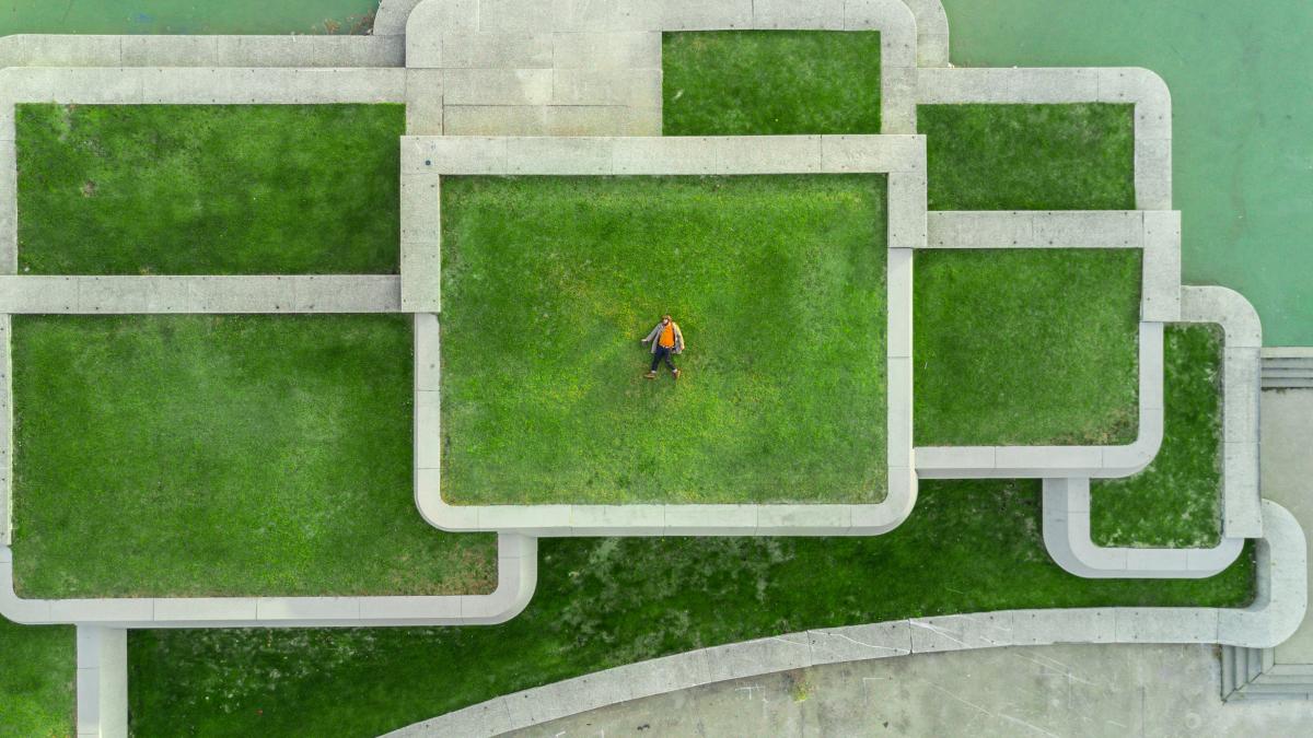 bird's eyeview photo of person lying on green grass