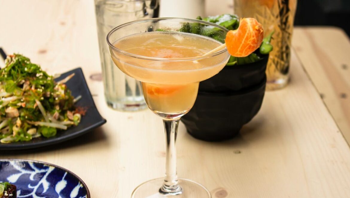 beverage filled clear cocktail glass on wooden surface