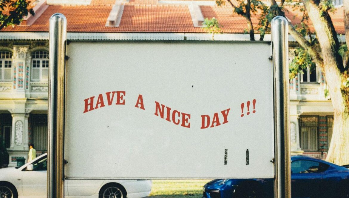 white and blue vehicles on road and have a nice day text on post