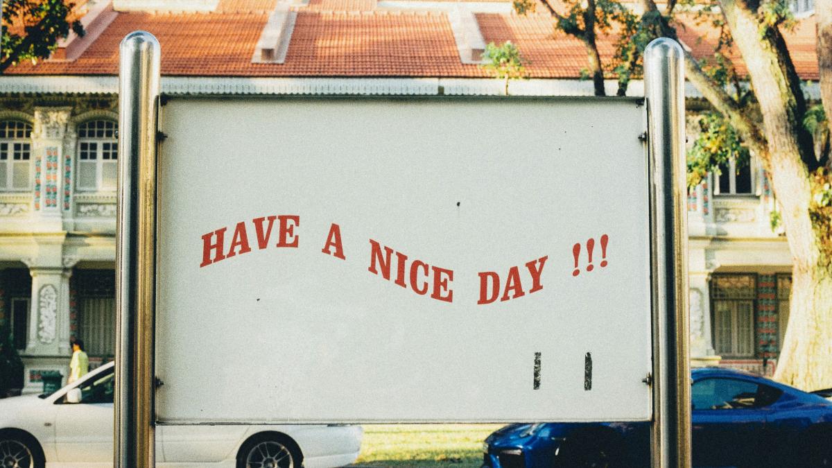 white and blue vehicles on road and have a nice day text on post