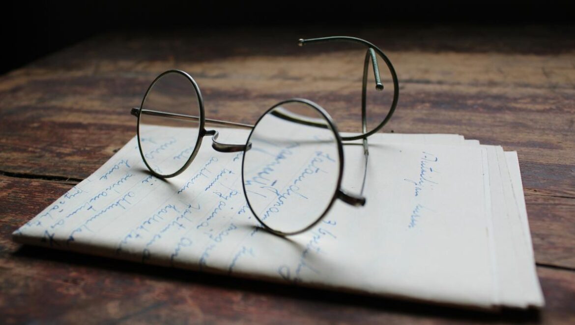 silver framed eyeglasses on white printer paper