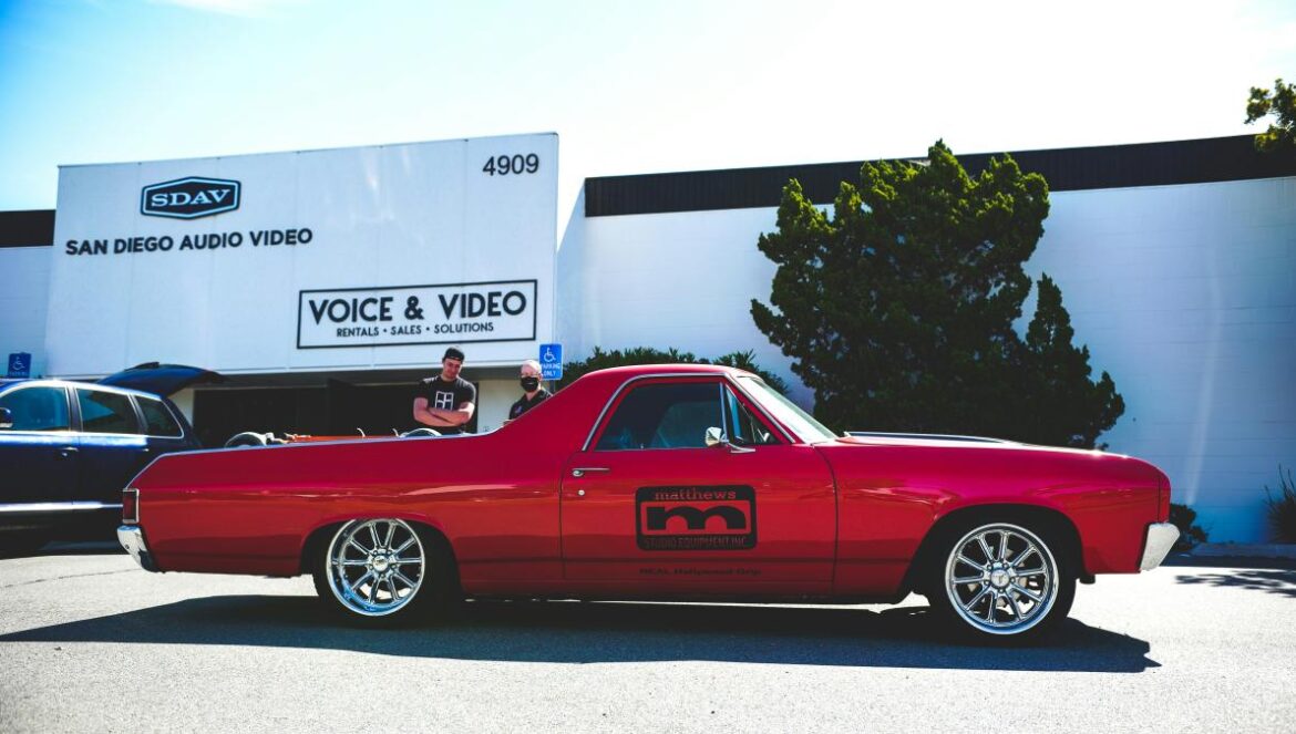 red coupe parked near white box truck