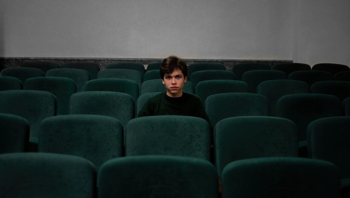 boy in blue shirt sitting on blue chair