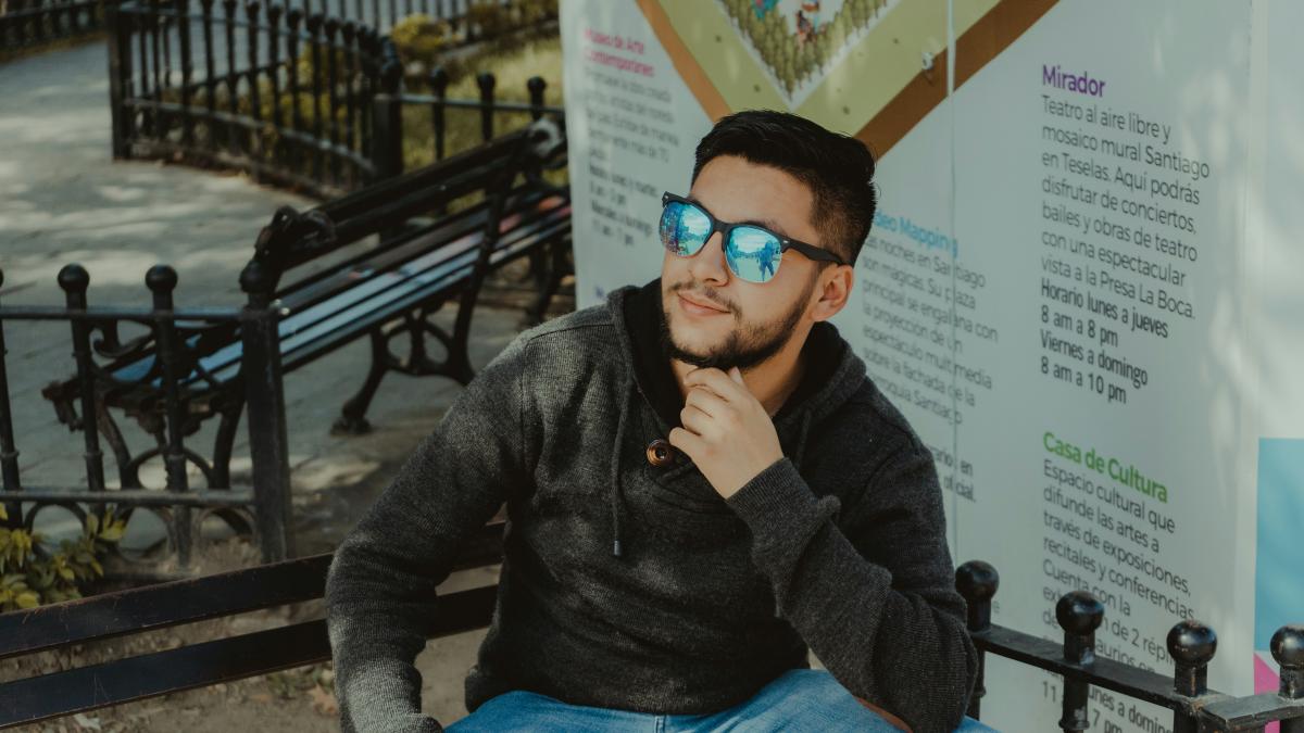 woman in gray sweater and blue denim jeans wearing black sunglasses