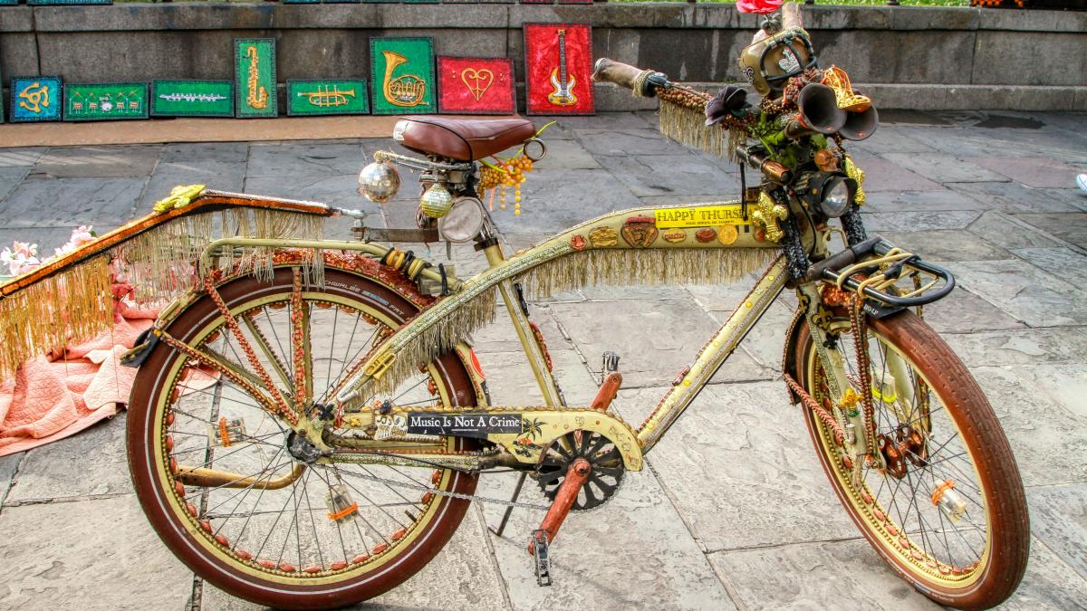 yellow city bike parked beside red metal fence