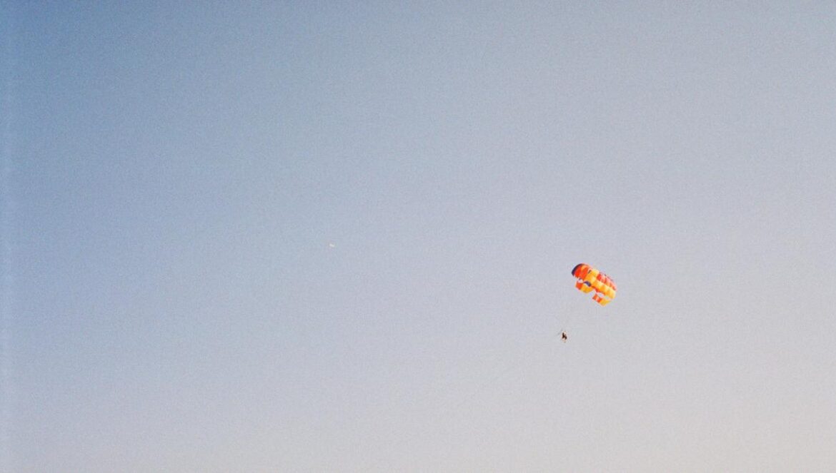 red and yellow parachute under blue sky during daytime