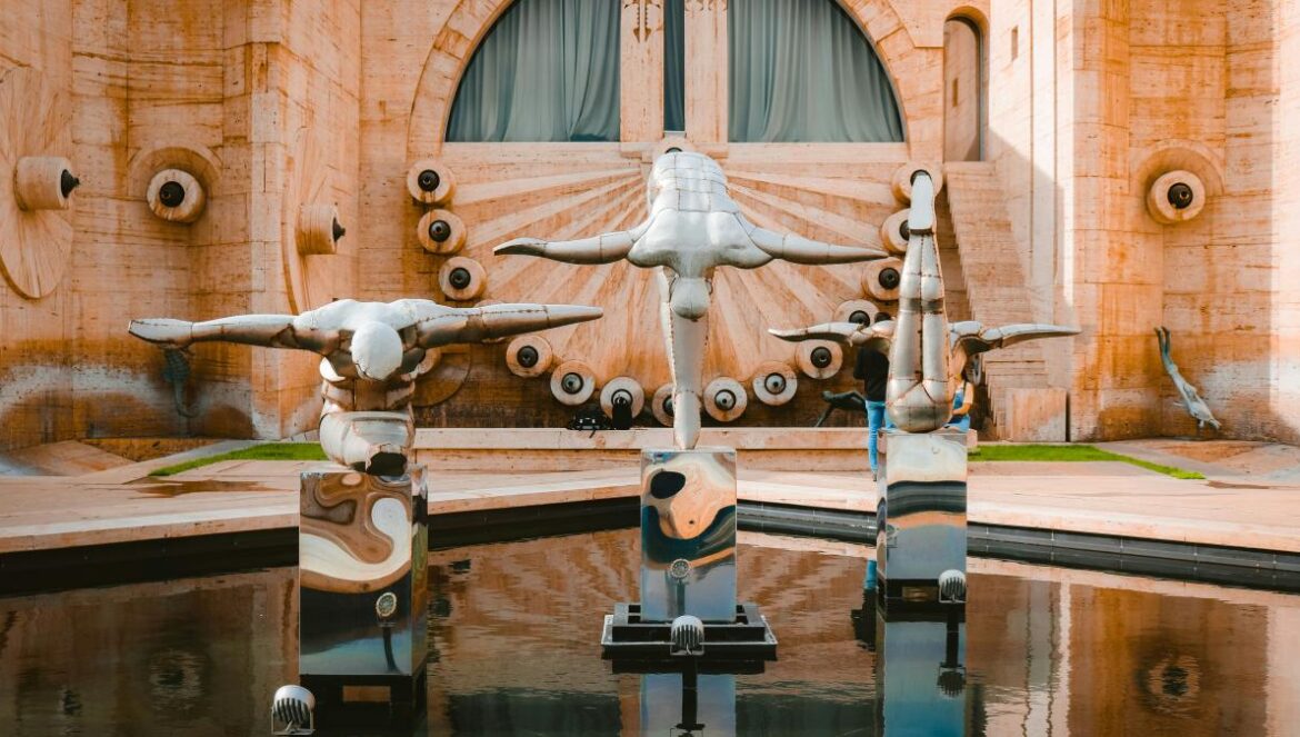 a group of sculptures sitting on top of a pool of water
