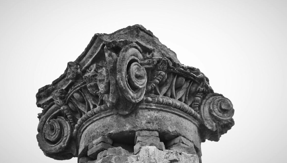 a black and white photo of a stone column