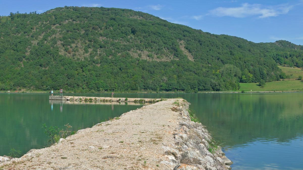 a body of water with boats on it and hills in the back