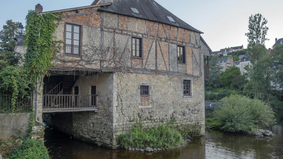 a stone building with a pond in front of it
