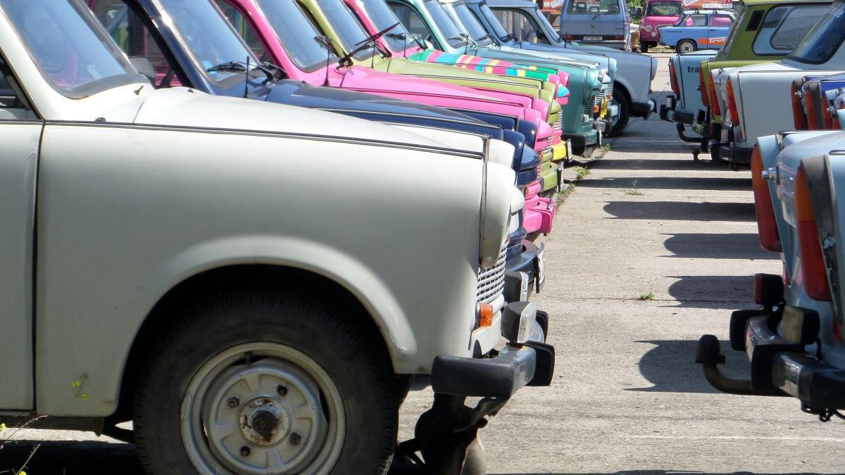 a row of parked cars sitting next to each other