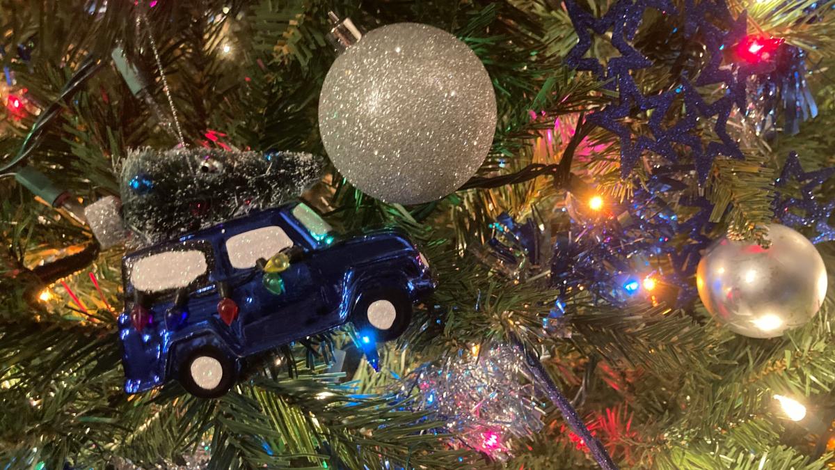 a christmas tree with ornaments and a toy car