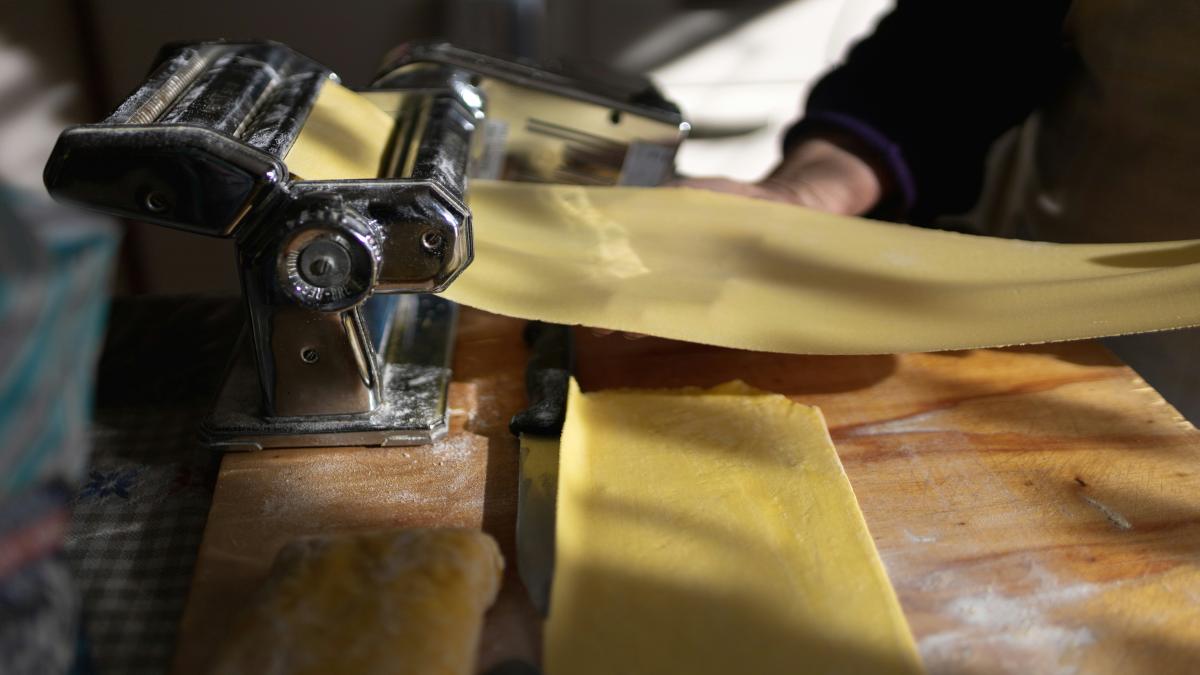 a person using a pasta cutter on a piece of yellow paper