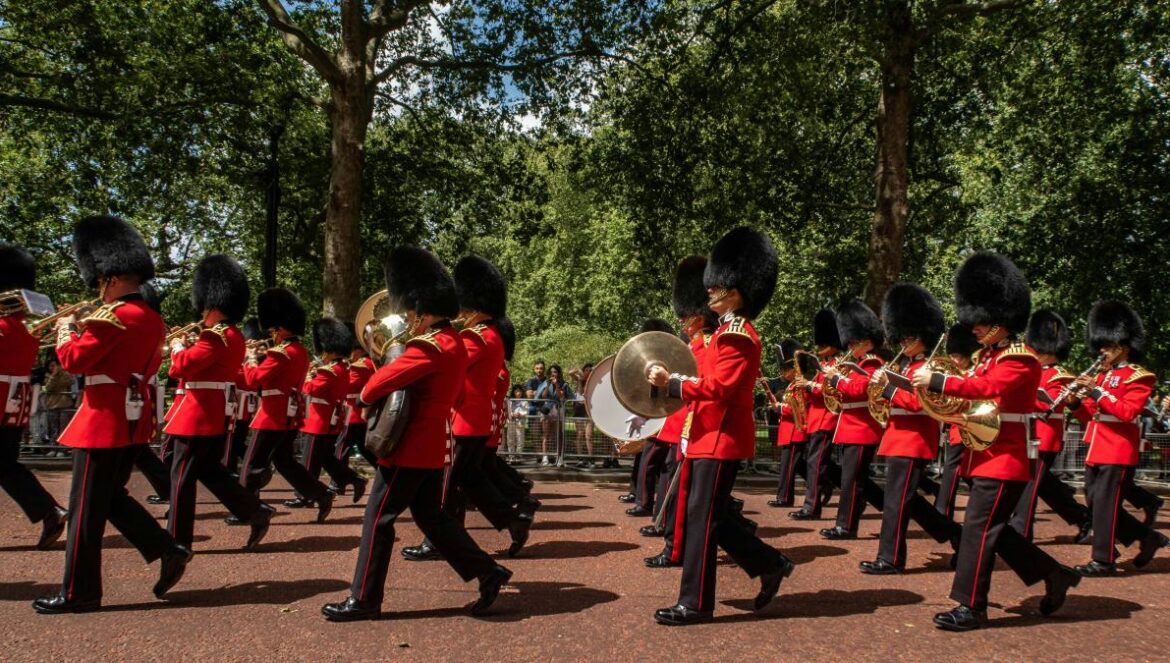 a group of men in red uniforms marching down a street