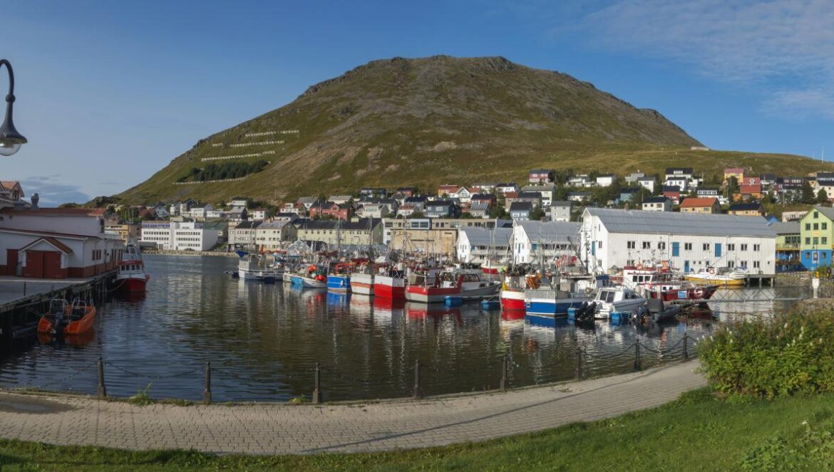 a harbor filled with lots of boats next to a mountain