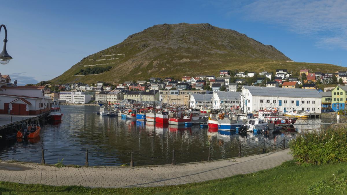 a harbor filled with lots of boats next to a mountain