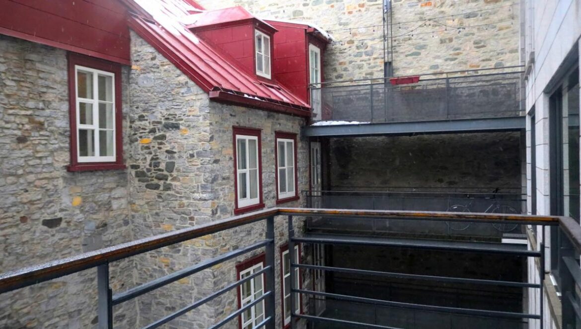 a building with a red roof and a balcony