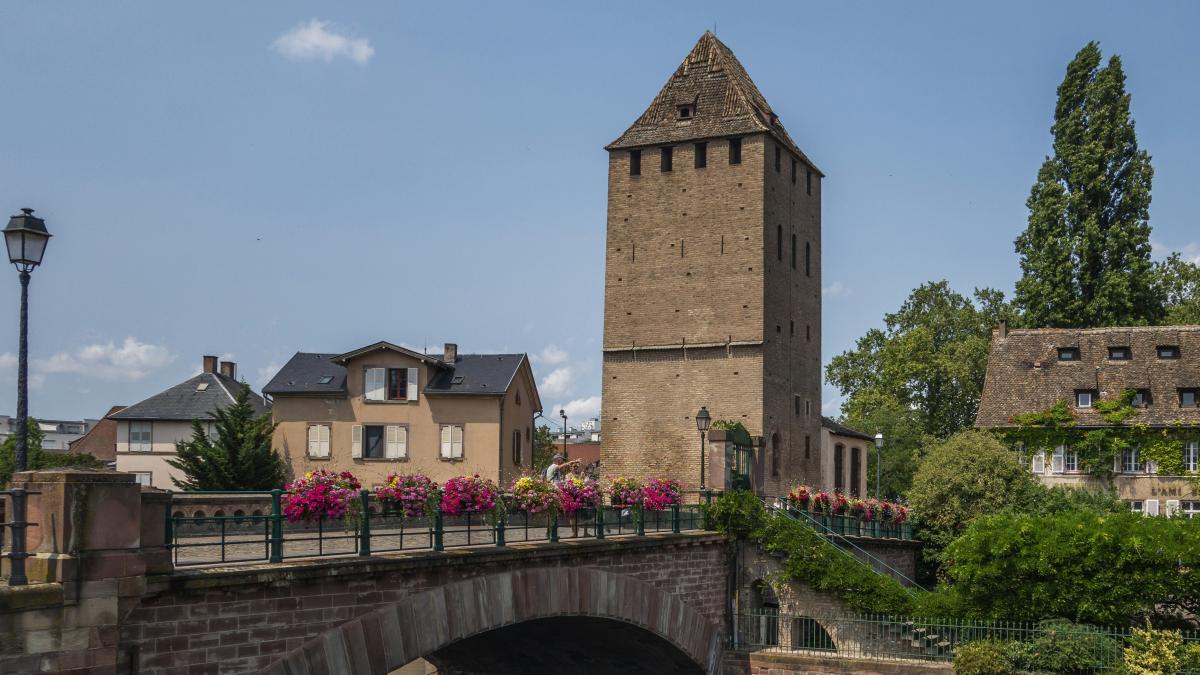 a bridge over a river with a clock tower in the background