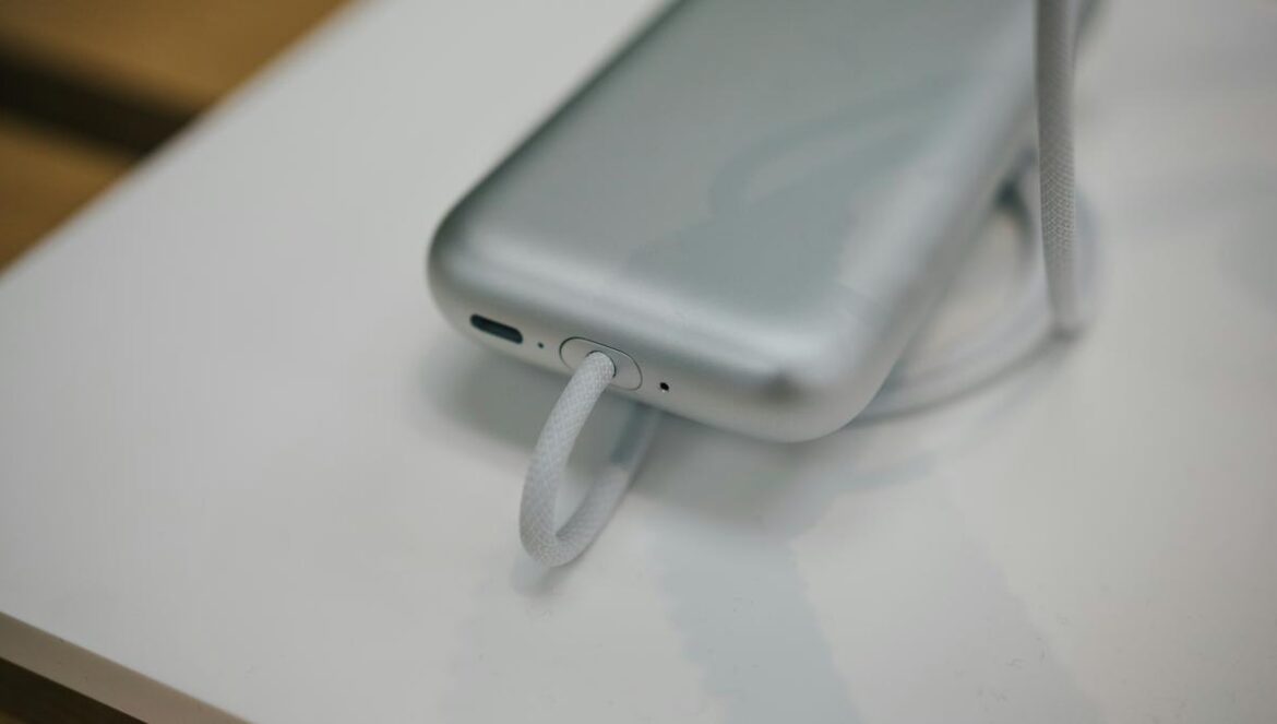 a cell phone plugged into a charger on a table