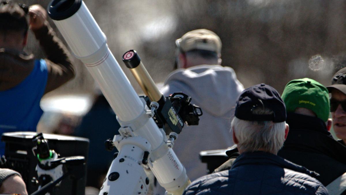 a group of people standing around a telescope
