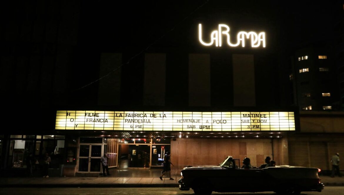a car parked in front of a theater at night