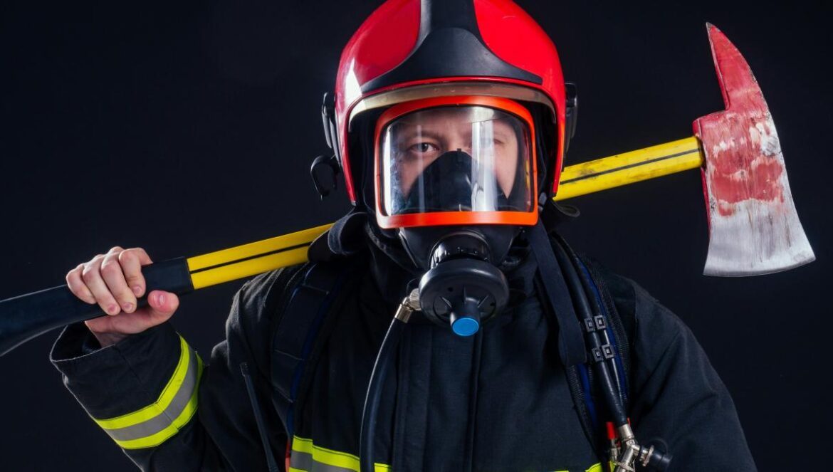 a fireman holding a large axe and wearing a helmet