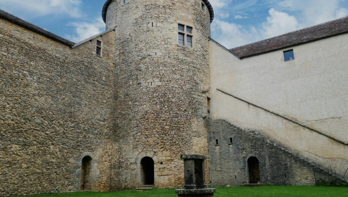 a stone building with a green lawn in front of it