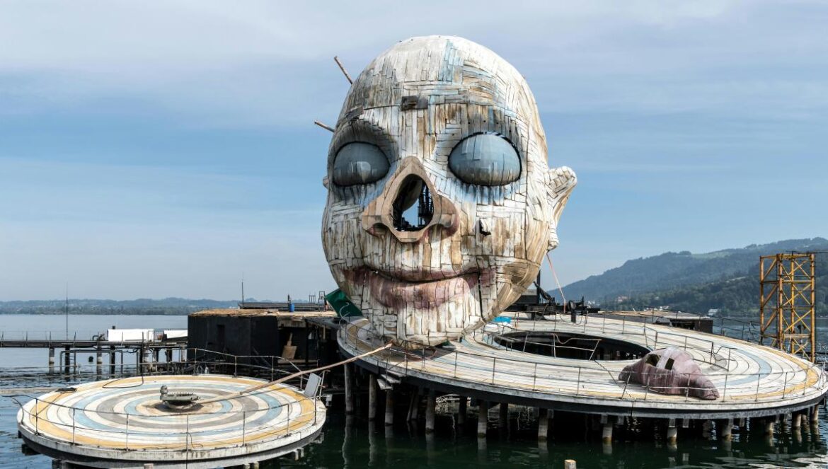 A sculpture of a human head on a pier
