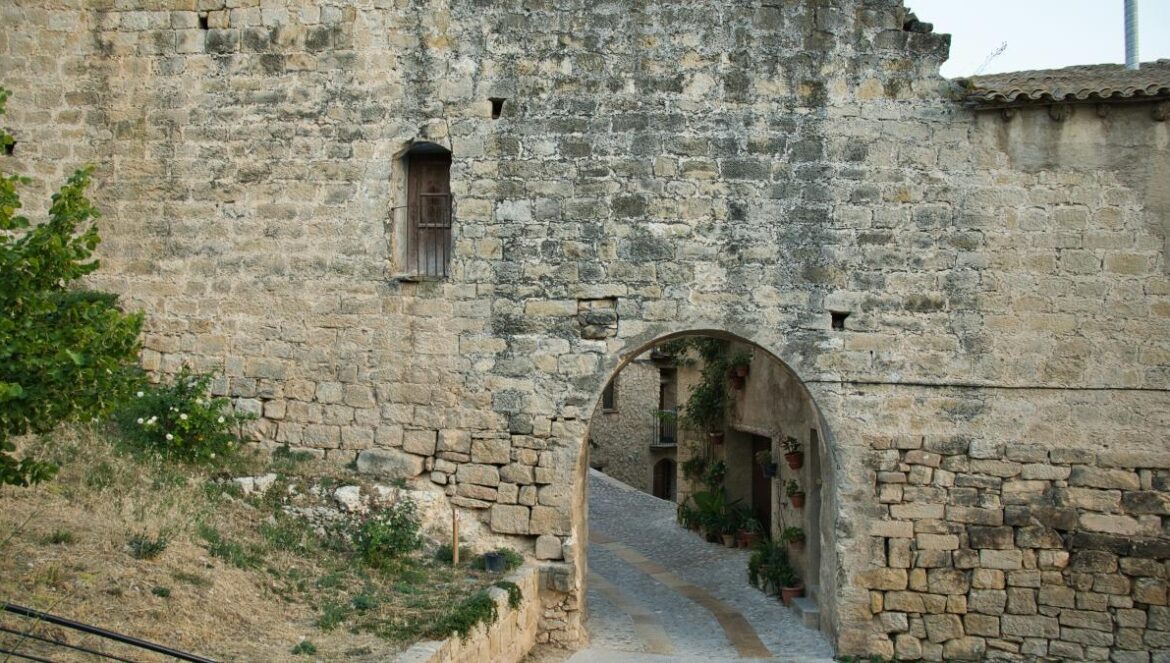 An old stone building with a gate and steps leading to it