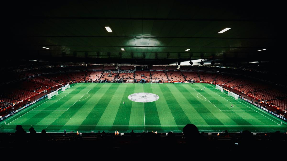 A large stadium with a green field in the middle of it