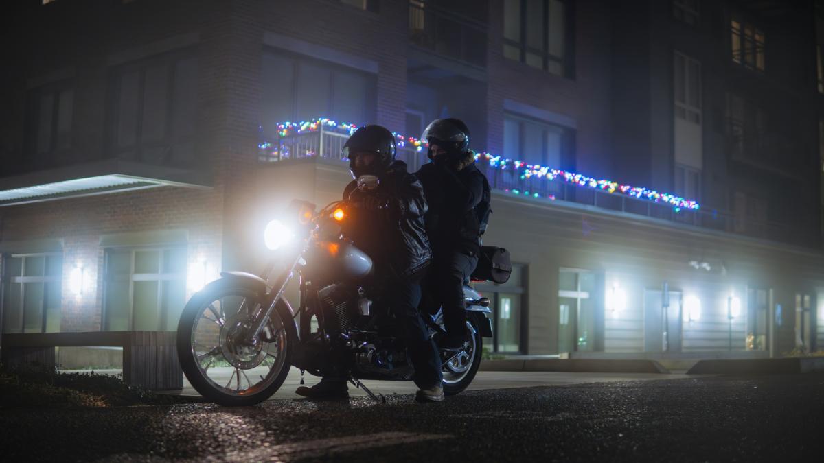 A couple of people riding on the back of a motorcycle