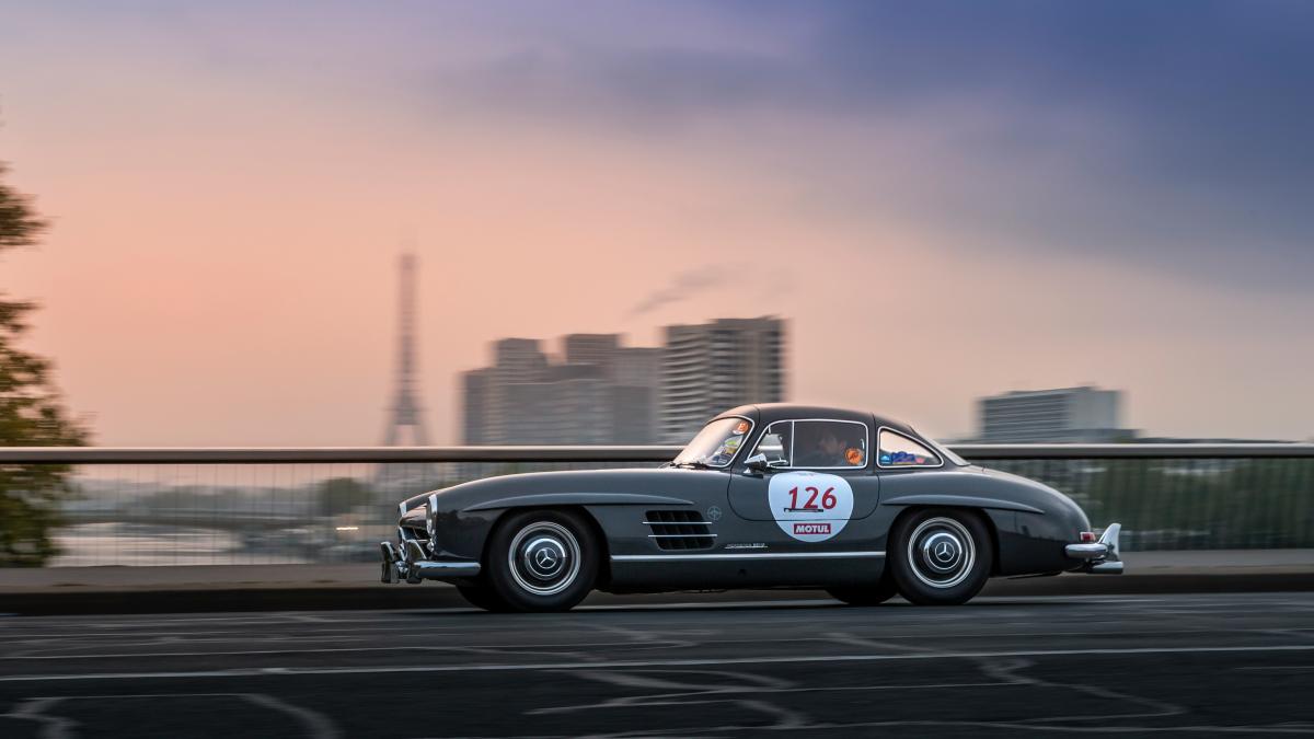 A car driving down a street next to a bridge