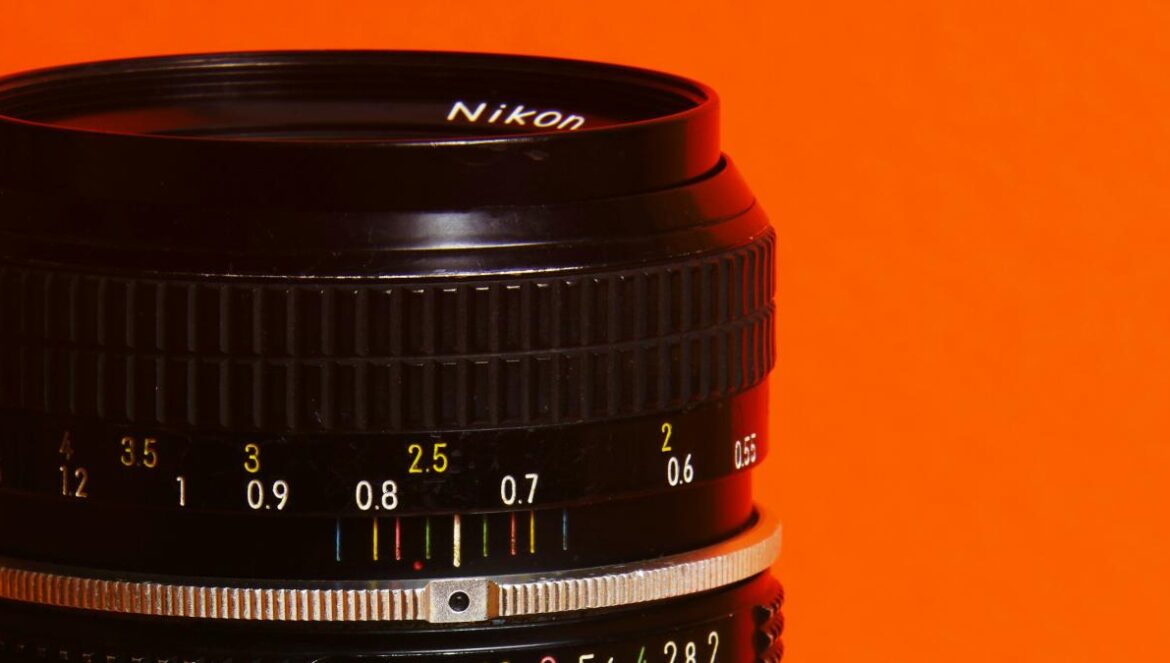 A close up of a camera lens on an orange background