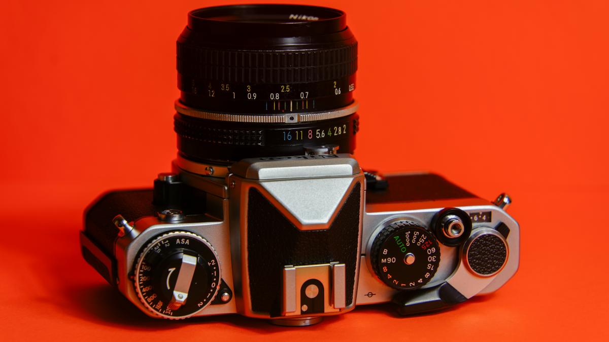A camera sitting on top of an orange background