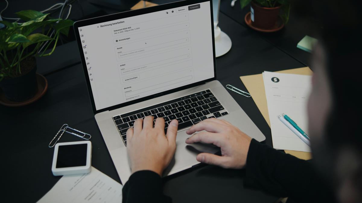 A person sitting at a desk using a laptop computer