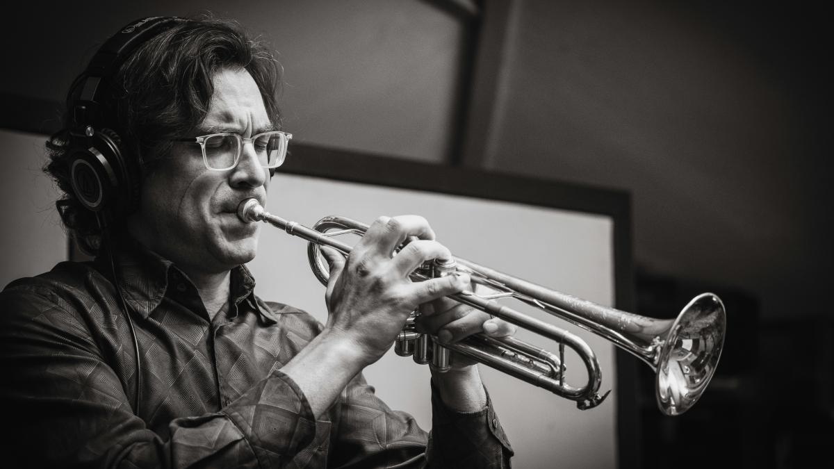 A man playing a trumpet in a recording studio