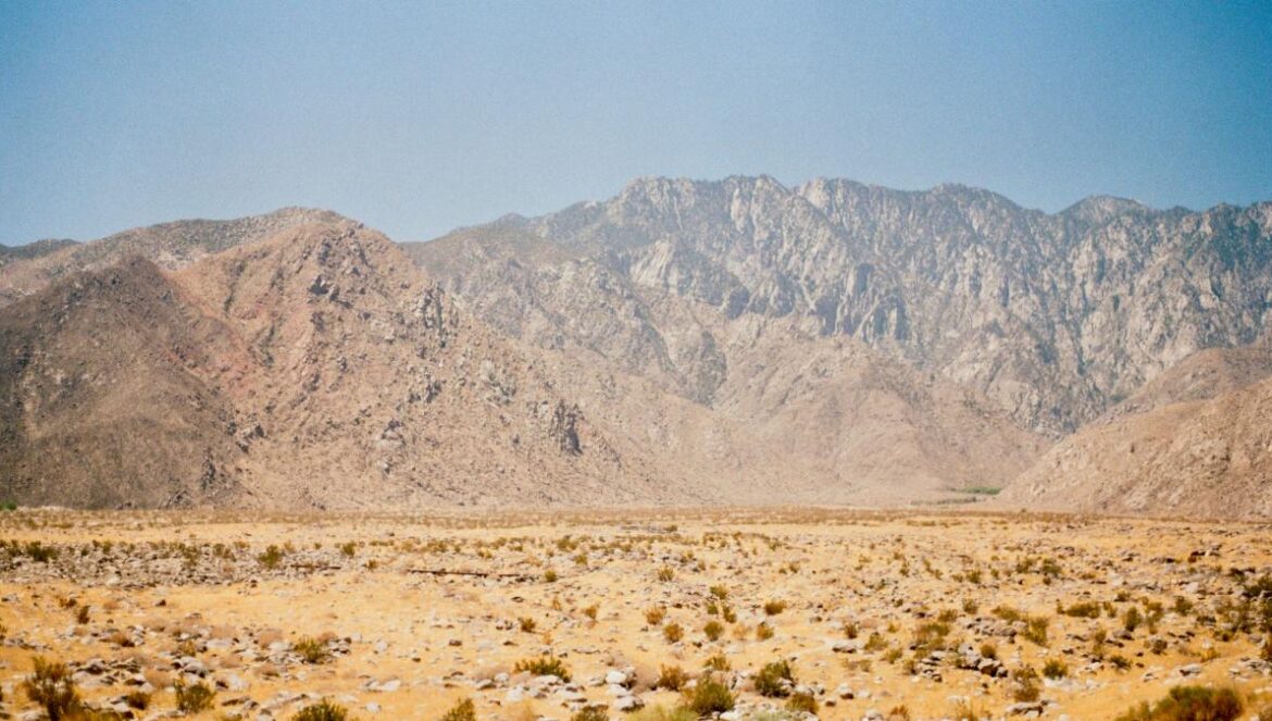 Mountains rise above a vast, arid desert landscape.