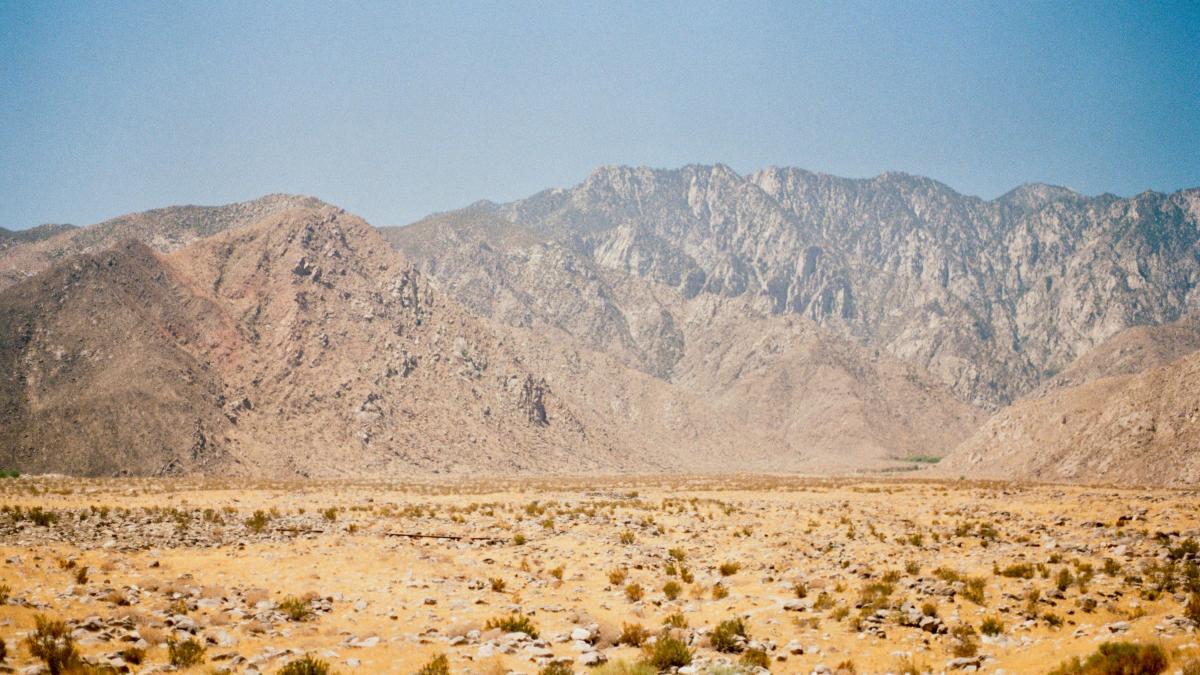 Mountains rise above a vast, arid desert landscape.